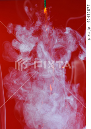 Pyrotechnics firecracker dynamite wick fuse burning with smoke and sparks on red background Pyrotechnics firecracker dynamite wick fuse burning with smoke and sparks on red background 62452877