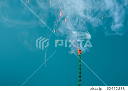 Burning fuse wick cord with sparks and smoke on blue background Burning fuse wick cord with sparks and smoke on blue background 62452888