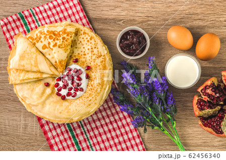 top view of traditional pancakes, jam, milk and square pattern napkin. delicious traditional dessert top view of traditional pancakes, jam, milk and square pattern napkin. delicious traditional dessert 62456340