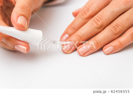 closeup beautiful female hands painting nails with transparent polish closeup beautiful female hands painting nails with transparent polish 62456355