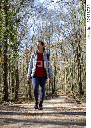 Pretty woman walking in the beech forest at 62458726