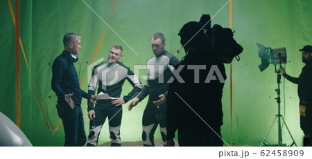 Director watching a shooting and discussing with an actor Director watching a shooting and discussing with an actor 62458909