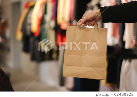 Hand with craft bag in clothing store. Male hand hilding bag with purchase 62460228