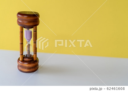 Selective focus of wooden hourglass on yellow Selective focus of wooden hourglass on yellow 62461608