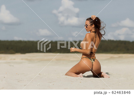 Seductive lady doing hair on beach 62463846