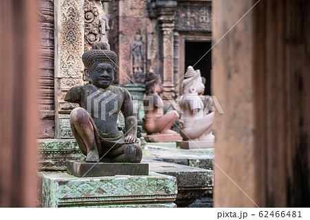 The demon statue guardian of the ancient ruins Banteay Srei the beautiful pink sandstone temple in old Khmer kingdom, Seam Reap, Cambodia. The demon statue guardian of the ancient ruins Banteay Srei the beautiful pink sandstone temple in old Khmer kingdom, Seam Reap, Cambodia. 62466481