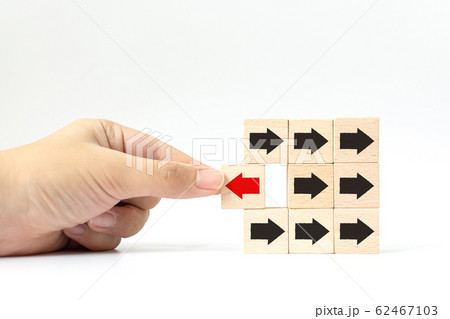 Hand choose wooden block with red arrow facing the opposite direction black arrows 62467103