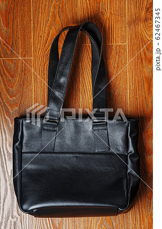 Black leather bag handmade on a wooden background Black leather bag handmade on a wooden background 62467345
