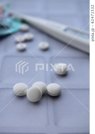 飲み薬の白い錠剤と体温計　治療イメージ 62471532