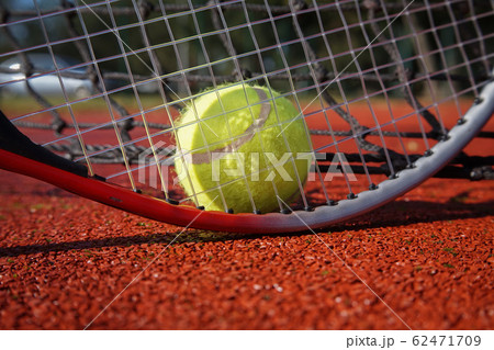 Tennis ball, racket and line on an outdoor court Tennis ball, racket and line on an outdoor court 62471709