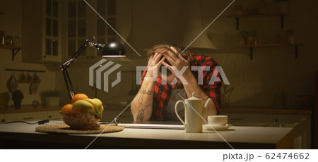 Man working late at night in the kitchen 62474662