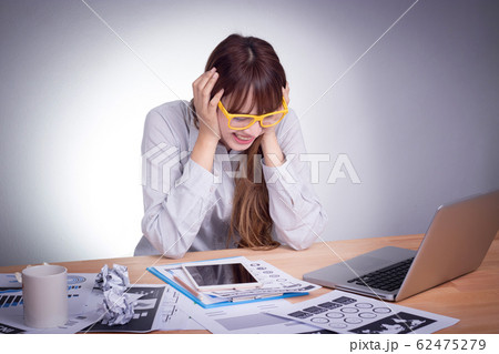 Feeling tired and stress. A stressed Asian business woman looks tired in her office 62475279