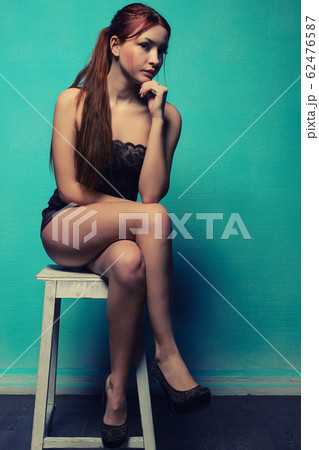 girl in underwear sitting on a stool against the girl in underwear sitting on a stool against the 62476587