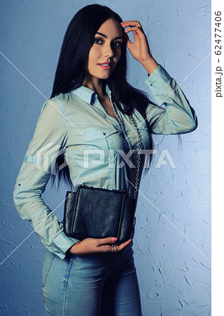 Beautiful stylish brunette in jeans holding a 62477406