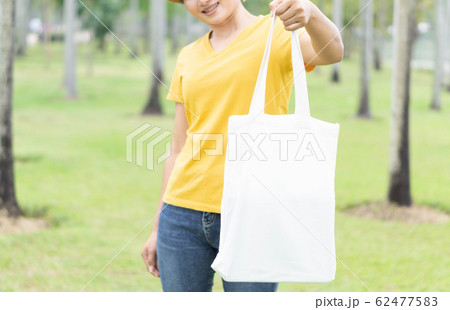Closeup woman hand holding white bag canvas fabric 62477583