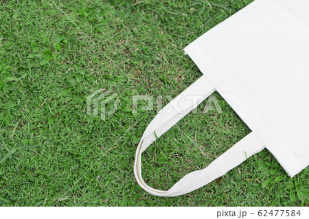 Closeup white bag canvas fabric on green grass 62477584