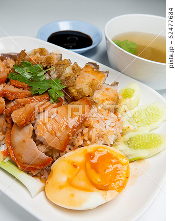 Barbecued red pork and crispy pork in sauce with rice, Chinese style roasted pork. closeup 62477684
