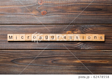 Microaggressions word written on wood block. 62478558