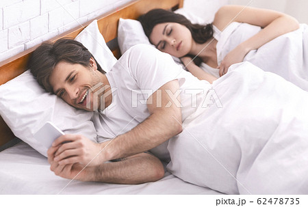 Young man watching adult videos on cellphone Young man watching adult videos on cellphone 62478735