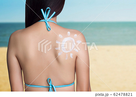 UV reflection skin after protection. Skin care concept. Woman applying sunscreen on her back with sea background. SPF sunblock protection concept. Travel vacation 62478821