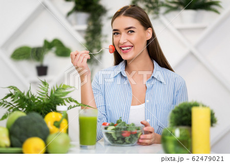 Diet and vegetarian concept. Happy woman eating vegetable salad 62479021