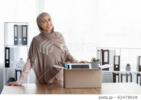 Female Office Employee Moving To New Desk With Box Full Of Belongings Female Office Employee Moving To New Desk With Box Full Of Belongings 62479039