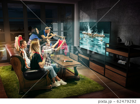 Group of friends watching TV, swimming sport games Group of friends watching TV, swimming sport games 62479292