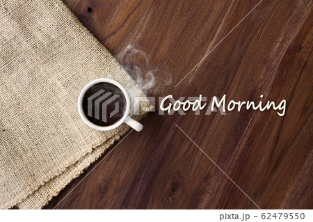 Cup of hot coffee with smoke on wooden table top view with word good morning. coffee background with copy space Cup of hot coffee with smoke on wooden table top view with word good morning. coffee background with copy space 62479550