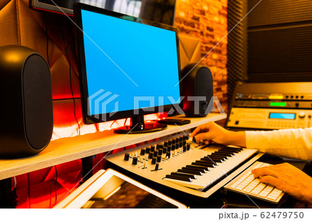 male music producer arranging a song on computer in sound studio male music producer arranging a song on computer in sound studio 62479750