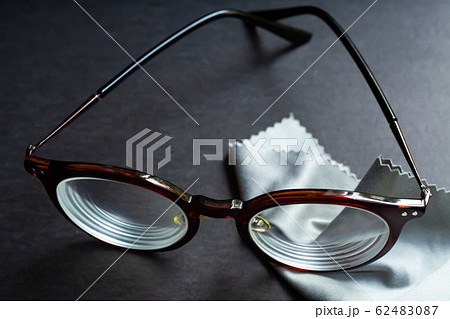 Brown shortsighted or nearsighted eyeglasses with microfibre cleaning cloths, On black background, Close up & Macro shot, Selective focus, Optical concept 62483087