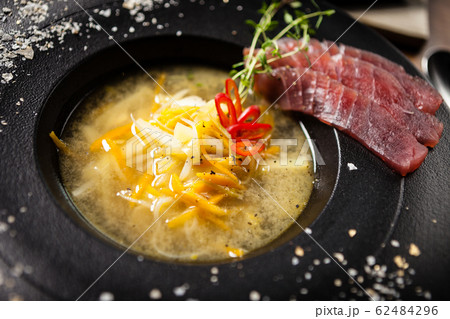 Clear Fish soup served in a bowl in restaurant Clear Fish soup served in a bowl in restaurant 62484296