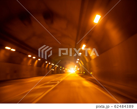 Blurred image of car riding in dark tunnel through mountain Blurred image of car riding in dark tunnel through mountain 62484389