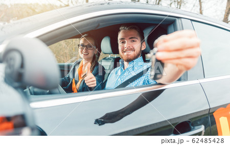 Student of driving school having passed his final test showing the car keys 62485428