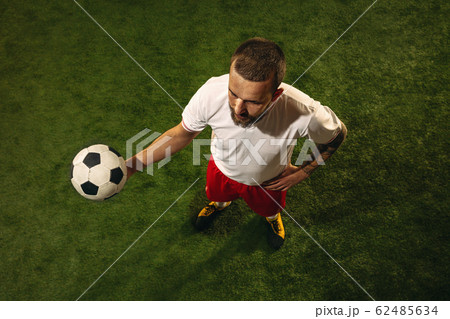 Top view of caucasian football or soccer player on green background of grass Top view of caucasian football or soccer player on green background of grass 62485634