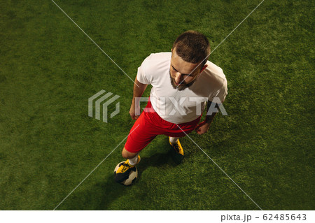 Top view of caucasian football or soccer player on green background of grass 62485643