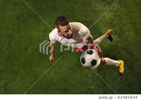 Top view of caucasian football or soccer player on green background of grass 62485644