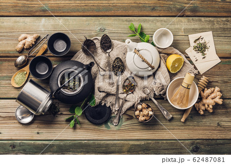 Various tea and teapots composition, dried herbal, green, black tea and matcha tea on wooden table background 62487081