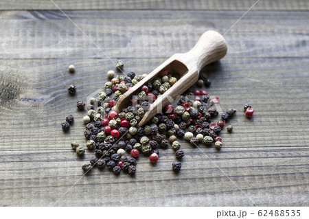 peppercorns on wooden spoon 62488535