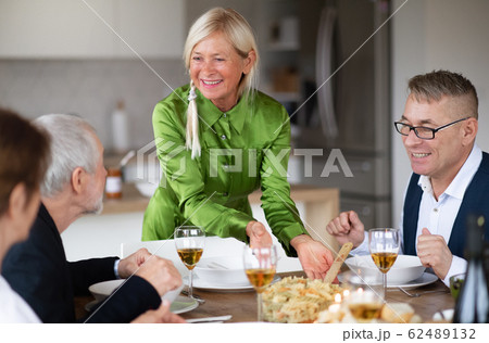 Group of senior friends at dinner party at home. 62489132