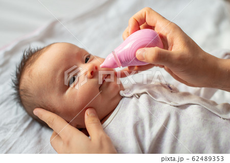 mother using baby nasal aspirator mucus nose suction mother using baby nasal aspirator mucus nose suction 62489353