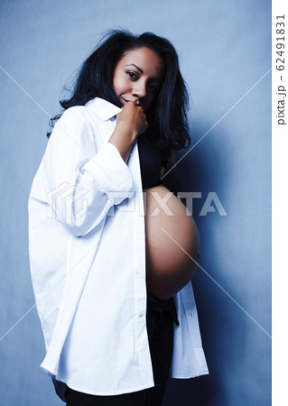 young pretty african american woman pregnant happy smiling, posing on blue background, lifestyle people concept copyspace 62491831