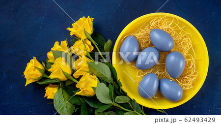 Close up of yellow roses and Easter eggs in a Close up of yellow roses and Easter eggs in a 62493429