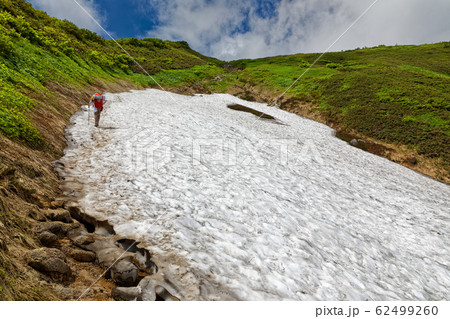 飯豊連峰稜線の雪渓を行く登山者 飯豊連峰稜線の雪渓を行く登山者 62499260