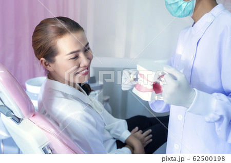 The dentist is demonstrating how to brush teeth 62500198