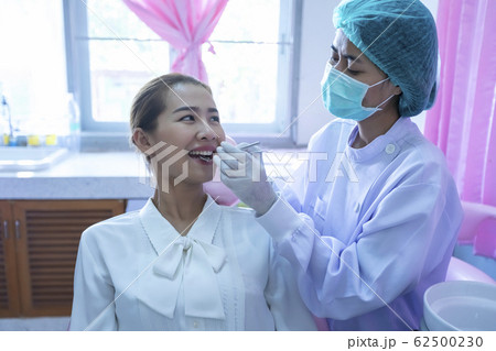 A beautiful woman giving the dentist a dental and A beautiful woman giving the dentist a dental and 62500230