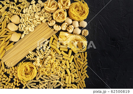Italian pasta design template with copy space, a flat lay of many different pasta types, shot from above on a black background with a place for text Italian pasta design template with copy space, a flat lay of many different pasta types, shot from above on a black background with a place for text 62500819