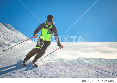 Skier practicing alpine skiing on the slope of a Skier practicing alpine skiing on the slope of a 62504605