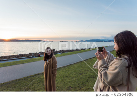 カナダで夕日を見る日本人女性 62504906