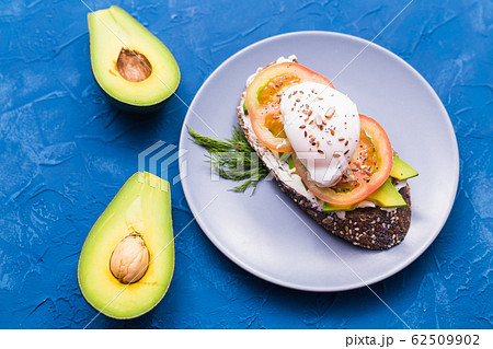 Sandwich with smoked salmon, egg and avocado on blue background, top view. Concept for healthy nutrition. Sandwich with smoked salmon, egg and avocado on blue background, top view. Concept for healthy nutrition. 62509902