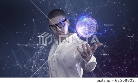 A male scientist in a white shirt holds an abstract ball in his hands against a background of plexus A male scientist in a white shirt holds an abstract ball in his hands against a background of plexus 62509905